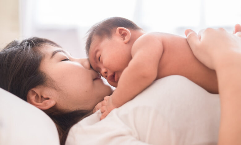 Happy mother holding adorable child baby boy