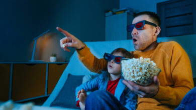 Father and daughter watching movie at home using 3D eye glasses