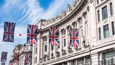 Close up of buildings on Regent Street London UK photographed from street level, with row of British flags to celebrate the Royal Wedding of Prince Harry to Meghan Markle.