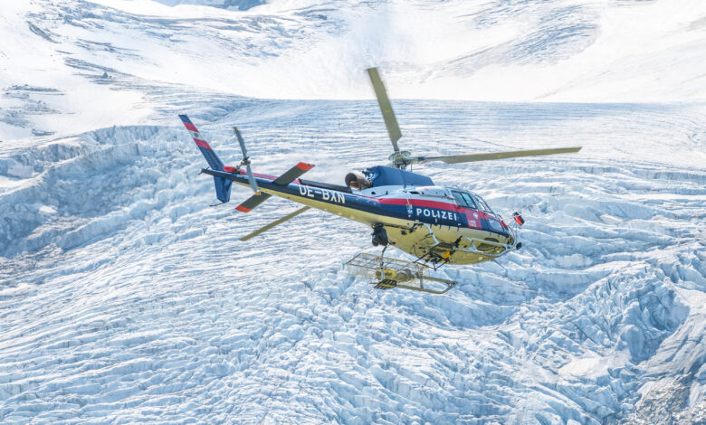 MATREI IN OSTTIROL, AUSTRIA - AUGUST 21, 2021: Austrian Police Air Support Helicopter - Eurocopter AS 350B Ecureuil. Montain glacier on background. Austria