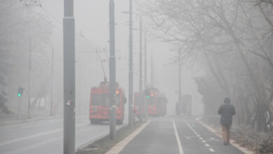 Visible air pollution at the streets of Belgrade, hazy foggy and polluted air and strong emission of CO2 due to industrial and man made pollution, with traffic moving slowly and people breathing it