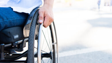 cropped image of man using wheelchair on street