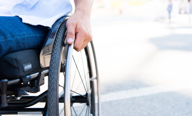 cropped image of man using wheelchair on street