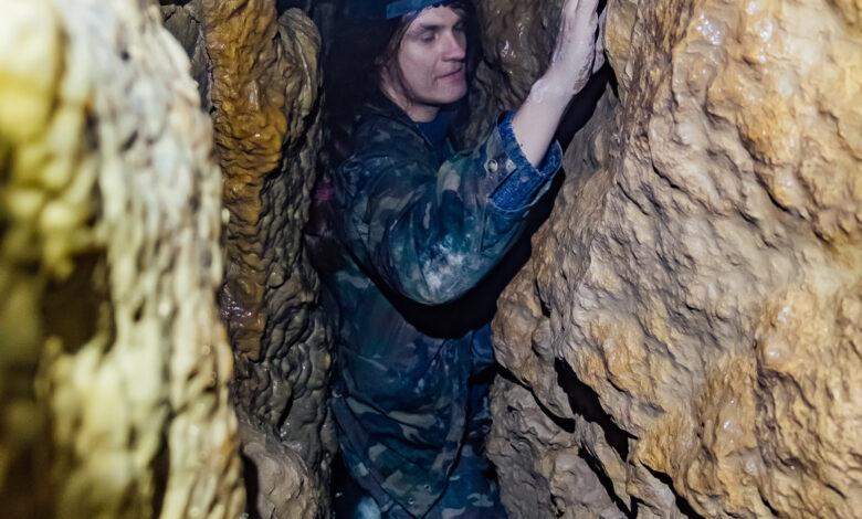 Man explores narrow cave