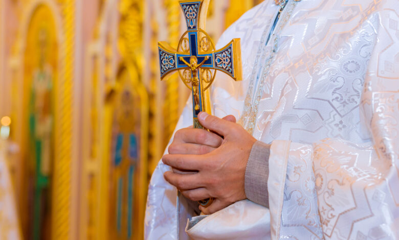 Orthodox priest holds with a cross in his hands