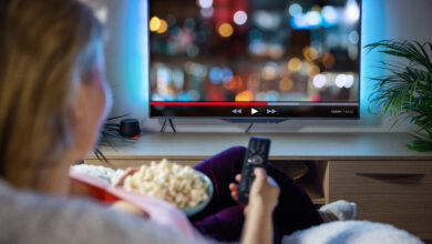 Woman relaxing at home in evening and watching TV